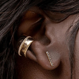 close up of woman's ear with black diamond bar studs and gold ear cuff