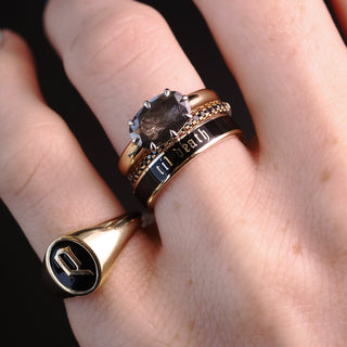 Hand wearing the 4mm black enamel Til Death band, Initial Enamel Signet Ring and Black Diamond Whisper band on a dark background