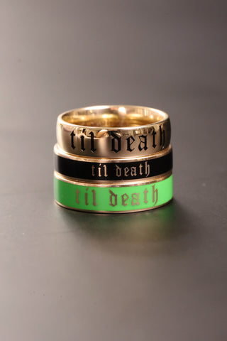 Three rings with 'til death' engraving on a gray background