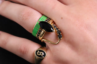 Close up of hand wearing scheele's green til death band stacked with black onyx rings
