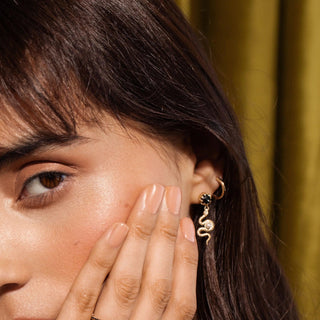 Black Diamond Serpent Swing Earrings close up on woman's ear