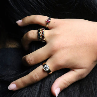 Image of a hand wearing rings. Pinky ring has the 0.88ct Ruby Sempre Ring, ring finger is wearing the Garnet Mixed Shape Milgrain Band + the Black Diamond Mixed Shape Band, and the pointer finger has the Arlo Engagement Ring From Marrow Fine with a round cut diamond. 