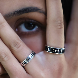 6mm silver Til Death enamel band worn on the middle finger, hand held over the face