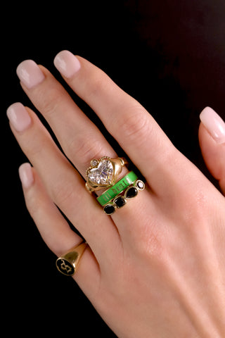 Hand wearing multiple rings with a dark background