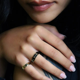 Til Death Gold Band worn on the hand against a dark background