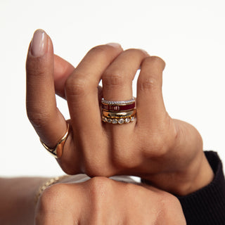 Close-up of a hand wearing multiple rings on a white background