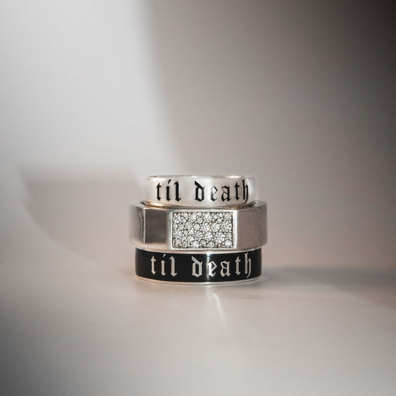 Three rings with 'til death' engraving on a gray background