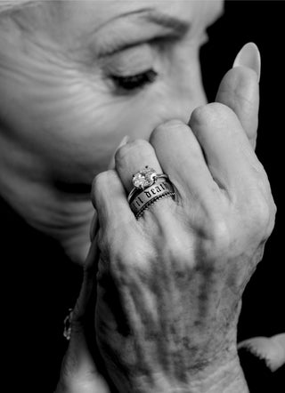 Close-up of a hand wearing multiple rings with a blurred background