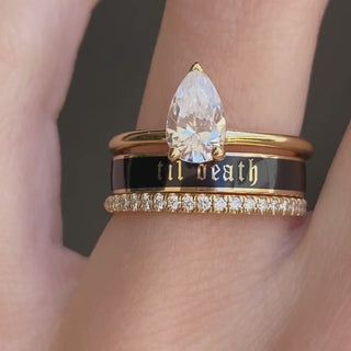 Video of the 4mm Til Death black enamel band stacked with a pear diamond engagement ring and a diamond band on hand