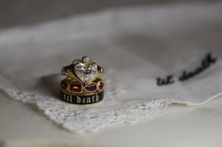Two rings on a lace fabric with 'till death' embroidery