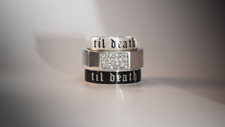 Three silver rings with 'til death' engraving on a gray background