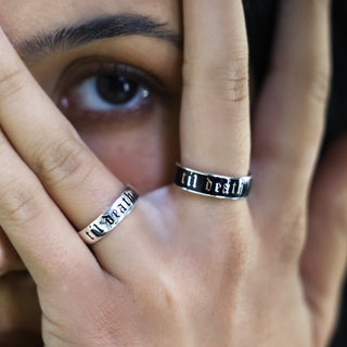 Hand near the eye wearing the sterling silver Til Death band and a 6mm silver and black enamel Til Death band