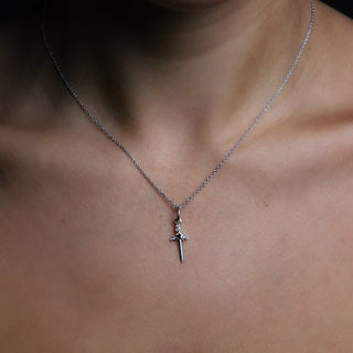 Small silver Cross My Heart dagger charm necklace worn with a black camisole