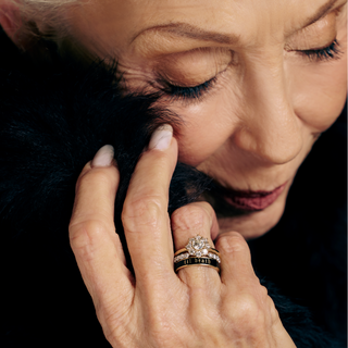 Close-up of a woman's hand with a diamond ring on a dark background