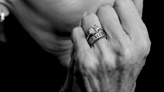 Close-up of a hand wearing multiple rings with a blurred background