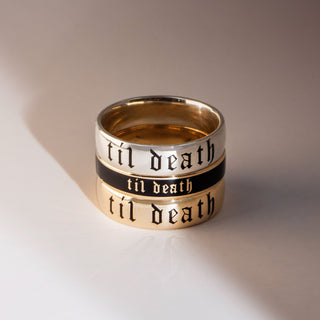 Three gold rings with 'til death' engraving on a beige background