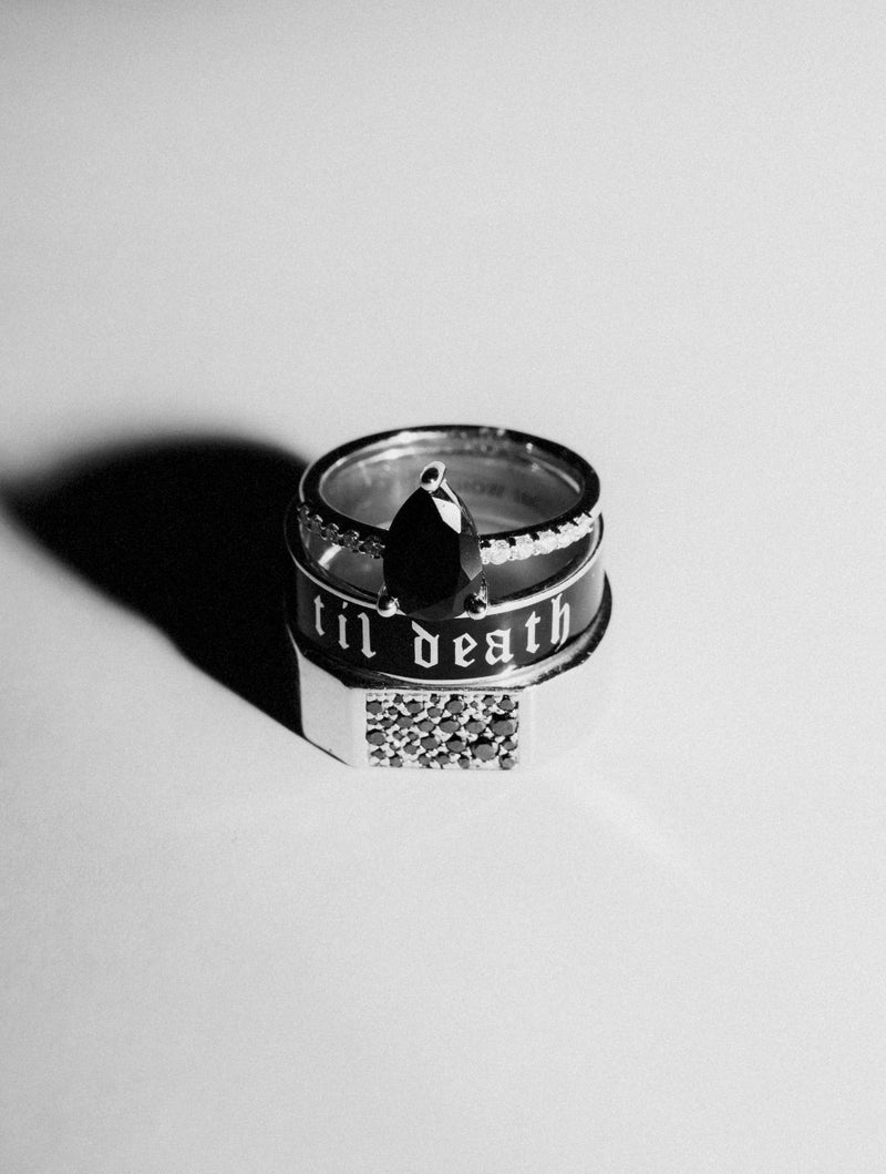 black and white image of ring stack with 'till death' engraving on a white background