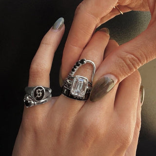 hand with silver and black diamond rings