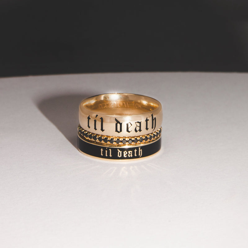 Gold ring with 'till death' engraving on a white surface